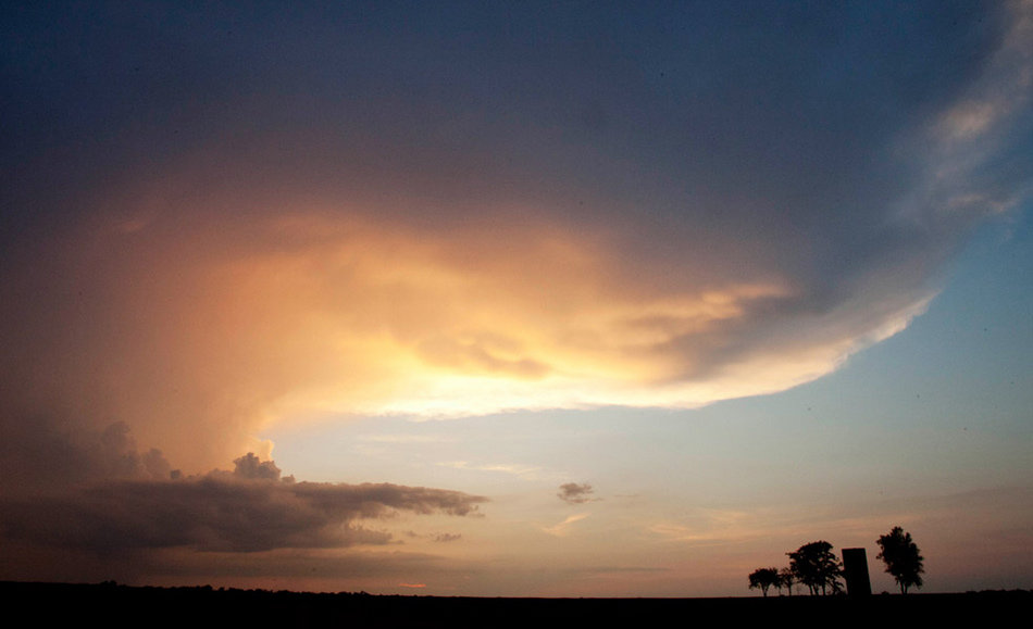 美国堪萨斯州威奇托市附近，暴风雨云逼近树林和一家农场上空。