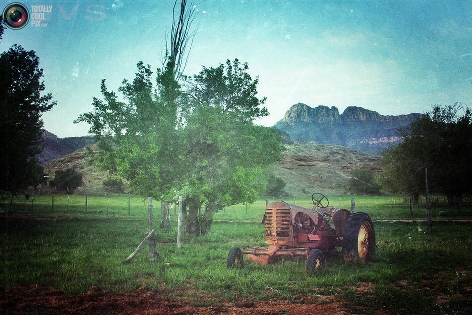 犹他州锡安国家公园，一个废弃农场的旧拖拉机躺在公园附近岩石的阴影中。