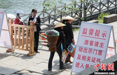 4月14日，两位当地居民众顺利的走过凤凰古城卡口。中新社发 一默 摄