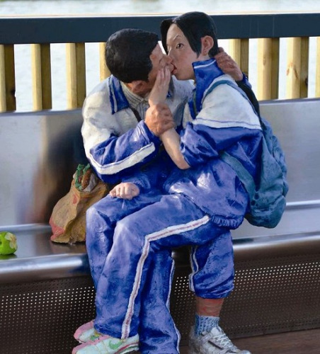 车站的休息长廊里，一对穿着校服的男女中学生当着众多候车人的面，玩起了“舌吻”