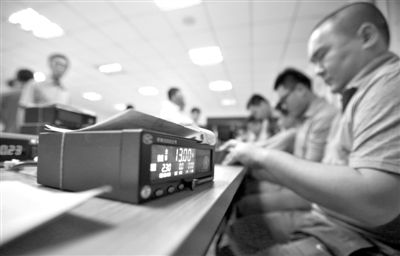 6月9日晚,工作人员在调出租车上拆下来的计价器。6月10日零时开始,本市出租车实行调价。新京报记者 浦峰 摄