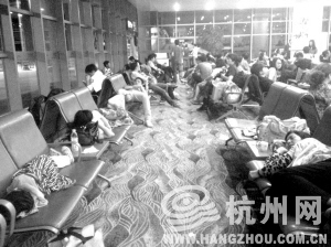 滞留丽江三义机场9个多小时后，昨晚11点多，许多乘客已累得趴下。 记者 金洁洁 摄