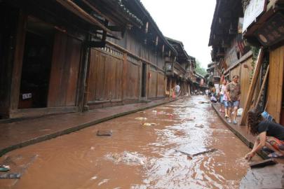 7月8日下午，洪水渐渐退去的上里古镇老街，居民们忙着清淤，抢救财物货品