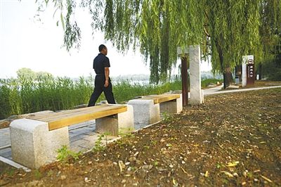 昨日,圆明园福海景区,游客经过“廓然大公”遗址。