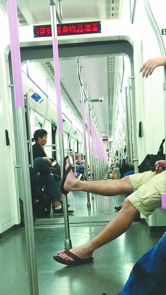 通往光谷方向的地铁上，一名男子把腿跷在扶手杆上