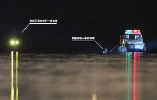 今天凌晨0:23,在事发地,一名工作人员在船上拉着绳子,绳子的另一端是没在水中的石塔。在他左侧发光的,是另一座完好的石塔。