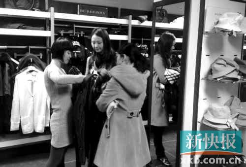 在巴宝莉专卖店内，华人游客正在挑选衣服。