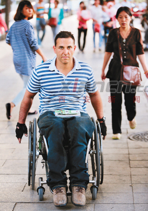 昨日，James双手滚动轮椅从西大街经过