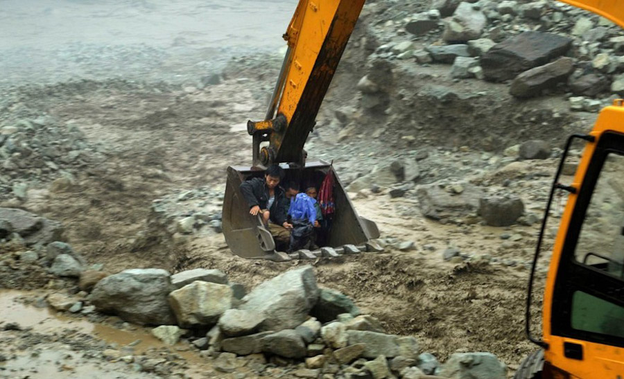 第10张 2013年7月10日，四川省汶川县，映秀发生泥石流和山体滑坡，一辆挖掘机正在将村民送往安全的地方，超过3万人将被疏散。