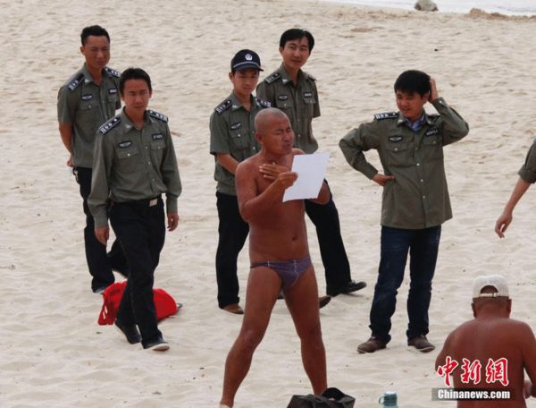  2月6日上午，执法人员在三亚大东海海滩向游人发放三亚市政府禁止在公共场所裸泳、裸晒的公告，劝说游人不要裸泳、裸晒。尹海明 摄