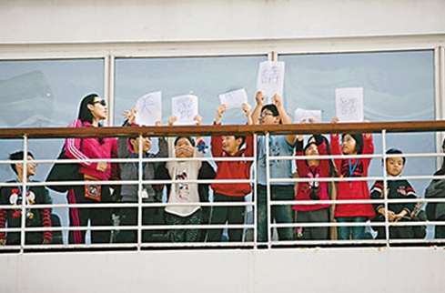 旅客自制标语在甲板上抗议。