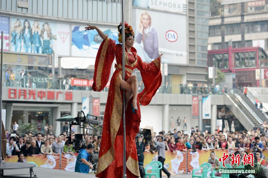 图为男选手林仙儿身穿古装，在钢管上演绎唐韵。