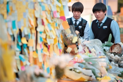 25日，檀园高中门口贴满了悼念遇难者的纸条。