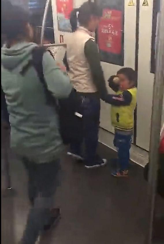 上海地铁行乞女被拍后打乘客 行乞男童：打死你
