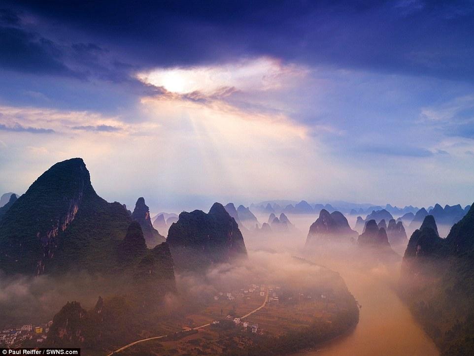 【中国广西桂林、日出】清晨，山脚下还在沉睡的小镇被笼罩在氤氲的晨雾中。为了拍这张照片，Reiffer在山上爬了三天三夜，几乎没合过眼。摄影师表示，实际上，日出日落光线最美的时刻非常短暂，仅仅只有几分钟。