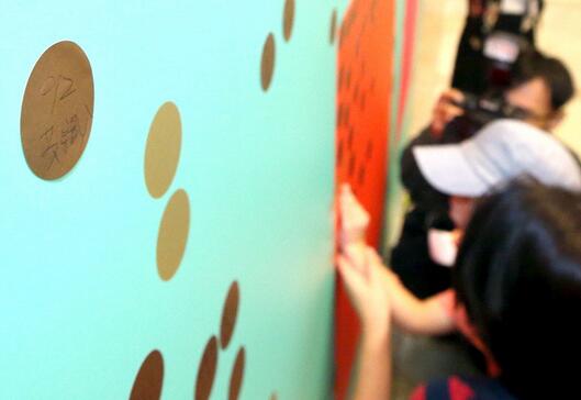 蔡英文办公室开放参观首日，陆客在贴板上写“九二共识”表祝福。