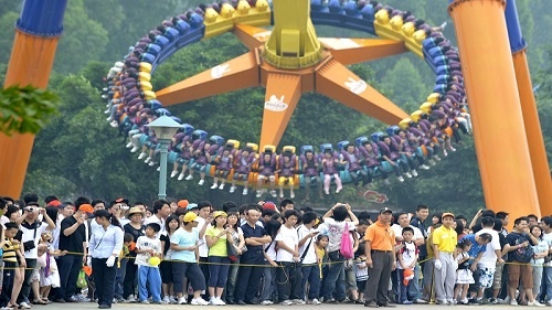 2018年5月1日，在广州长隆欢乐世界景区内，游客排起长队等待游乐项目。新华社记者 刘大伟 摄